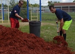 Machinist's Mate 1st Class Brian Hill (R) and Engineman 1st Class Robin Mosely (L) shovel mulch into a makeshift wheel-barrow at Oak Hill Academy in Jacksonville, Fla. Hill and Mosely are Sailors with Southeast Regional Maintenance Center (SERMC) in Mayport, Fla. Both volunteered to help clean, assemble furniture and prepare classrooms for the 2016-2017 school year. SERMC provides surface ship maintenance, modernization and technical expertise in support of the ships of the US Navy. Photo by Scott Curtis