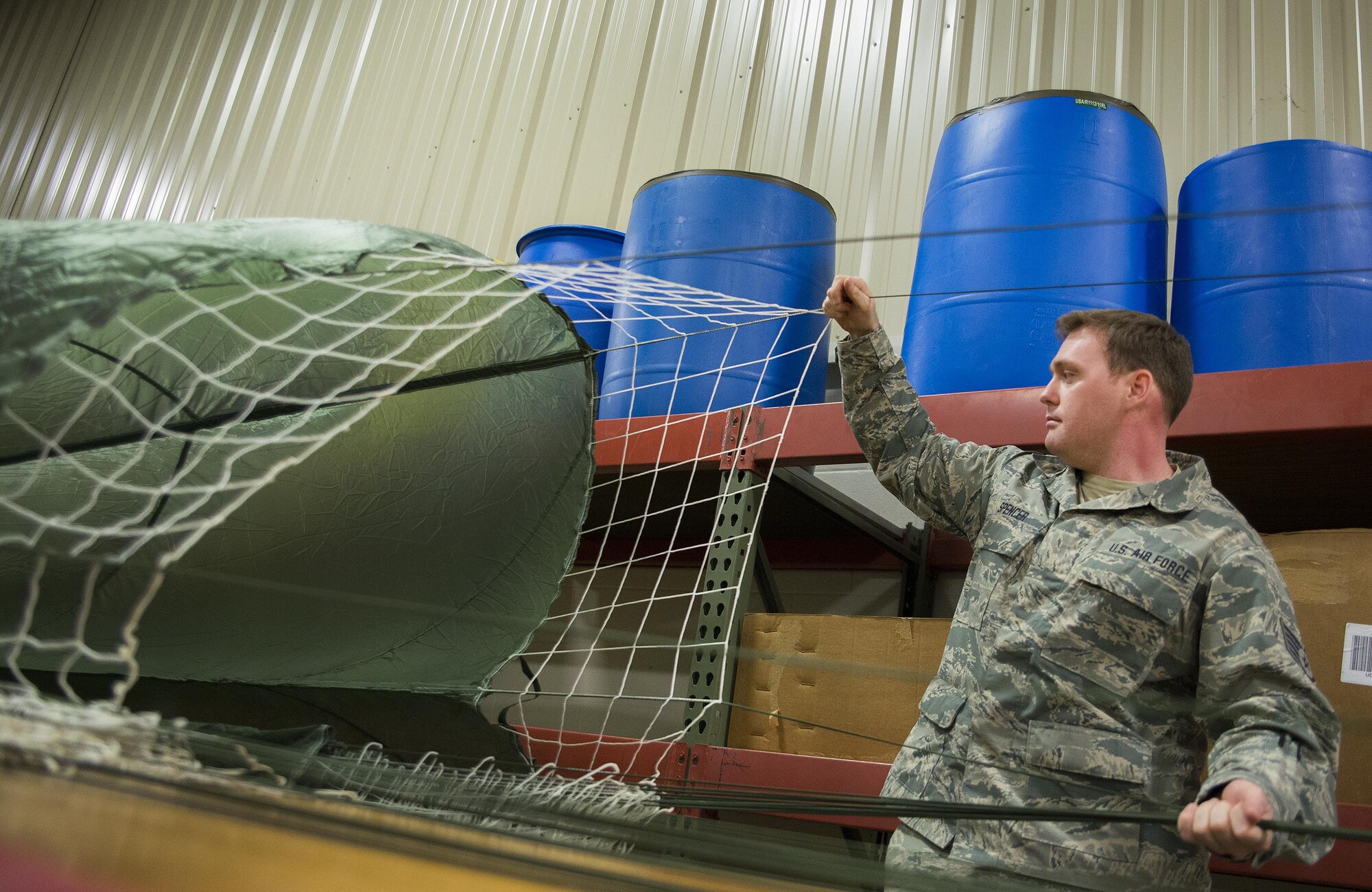 Staff Sgt. Justin Spencer, 919th Special Operations Logistics Readiness Squadron, sets up a parachute at Duke Field, Fla.  The parachutes are attached to 300-pound bundles and loaded onto aircraft so new loadmasters can perform their initial airdrop training and prior-qualified Airmen can maintain proficiency.  (U.S. Air Force photo/Sam King)  