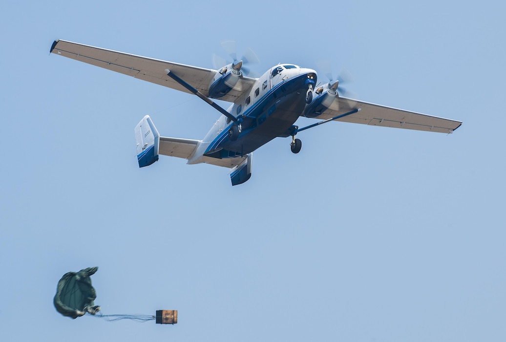 A parachuted bundle soars out of the back of a C-145 Skytruck during an airdrop mission over the Eglin Air Force Base range.  New and prior-qualified loadmasters release sandbags and 300-pound boxes from the 919th Special Operations Wing aircraft to as part of their initial airdrop or proficiency training.  The 919th Special Operations Logistics Readiness Squadron’s Airmen are responsible for packing, securing and recovering the equipment and parachutes.  (U.S. Air Force photo/Sam King)  