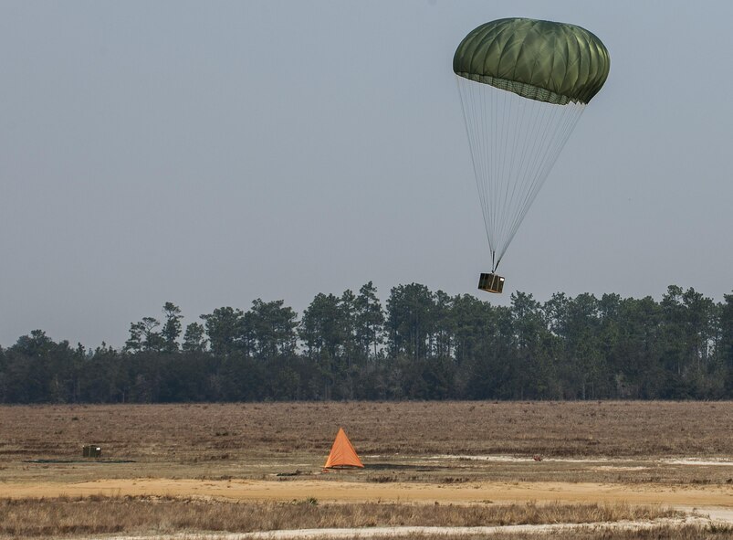 A parachuted bundle floats down into the landing zone after exiting a C-145 Skytruck during an airdrop mission over the Eglin Air Force Base range.  New and prior-qualified loadmasters release sandbags and 300-pound boxes from the 919th Special Operations Wing aircraft to as part of their initial airdrop or proficiency training.  The 919th Special Operations Logistics Readiness Squadron’s Airmen are responsible for packing, securing and recovering the equipment and parachutes.  (U.S. Air Force photo/Sam King)  