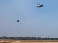A parachuted bundle soars out of the back of a C-145 Skytruck during an airdrop mission over the Eglin Air Force Base range.  New and prior-qualified loadmasters release sandbags and 300-pound boxes from the 919th Special Operations Wing aircraft to as part of their initial airdrop or proficiency training.  The 919th Special Operations Logistics Readiness Squadron’s Airmen are responsible for packing, securing and recovering the equipment and parachutes.  (U.S. Air Force photo/Sam King)  