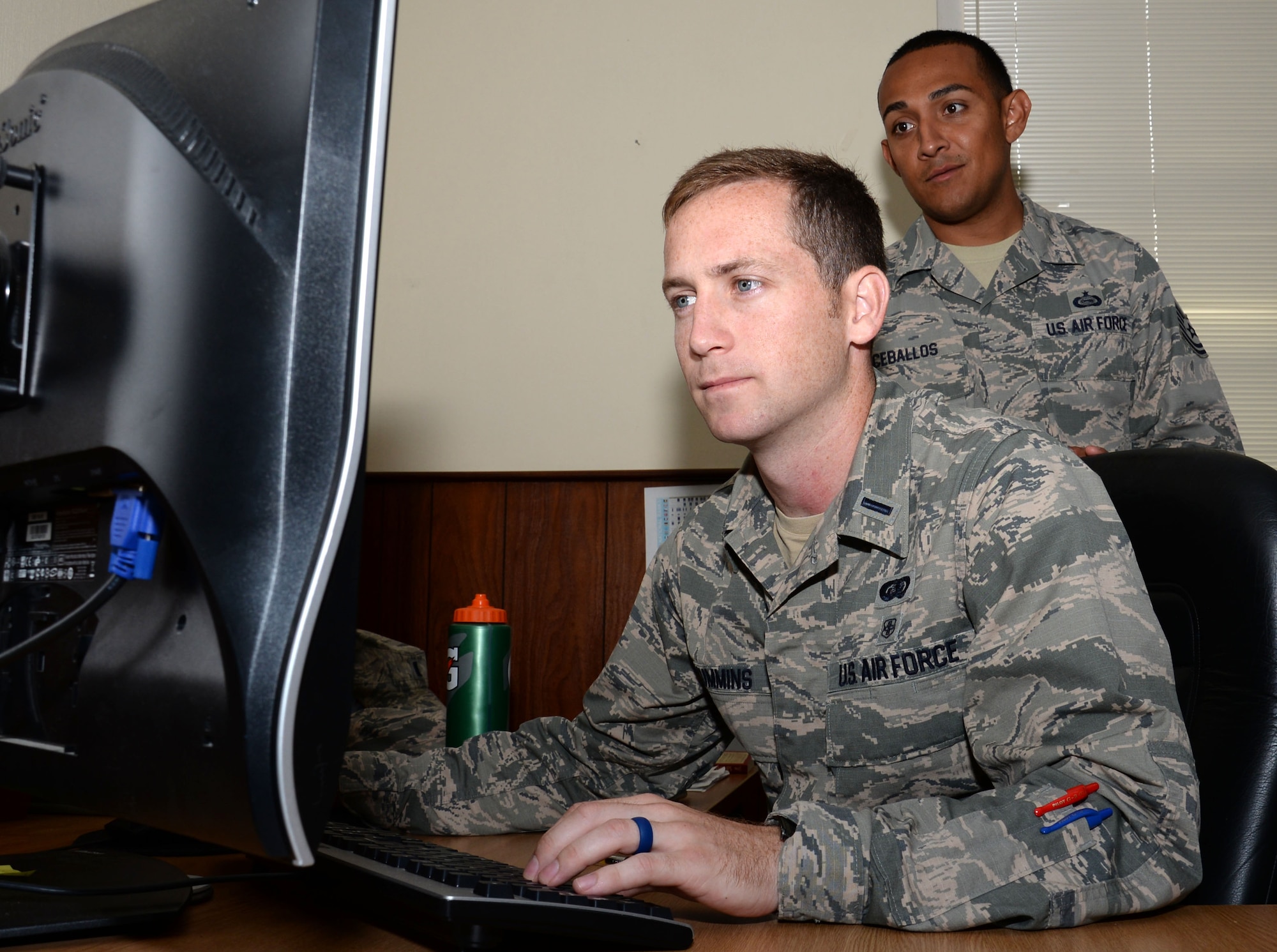 U.S. Air Force 1st Lt. Micah Cummins, left, 100th Air Refueling Wing chief of protocol and U.S. Air Force Tech. Sgt. Ricky Ceballos, 100th Air Refueling Wing NCO in charge of protocol, check the itinerary for an upcoming distinguished visitor tour Aug. 3, 2016, on RAF Mildenhall, England. Cummins has a stressful role in the military and enjoys soccer in his spare time as a way to keep fit and relax. (U.S. Air Force photo by Gina Randall)