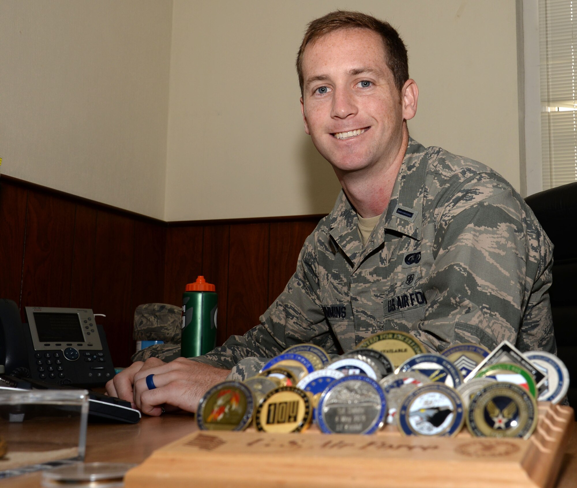 U.S. Air Force 1st Lt. Micah Cummins, 100th Air Refueling Wing chief of protocol, poses for a photograph in his office Aug. 3, 2016, on RAF Mildenhall, England. Cummins’ father was a coach for youth soccer at night and he taught his son a sport that he still enjoys many years later. (U.S. Air Force photo by Gina Randall)
