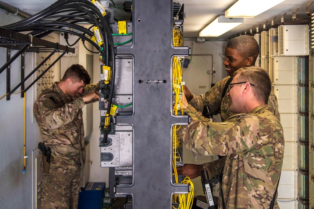 Air Force Senior Airmen Isiah Chaney, left, Christopher Collins, foreground, and Airman 1st Class Reginald Maffett remove unused network cables during a system upgrade at Bagram Airfield, Afghanistan, July 29, 2016. Chaney, Collins and Maffett are network management technicians assigned to the 455th Expeditionary Communications Squadron. Air Force photo by Senior Airman Justyn M. Freeman