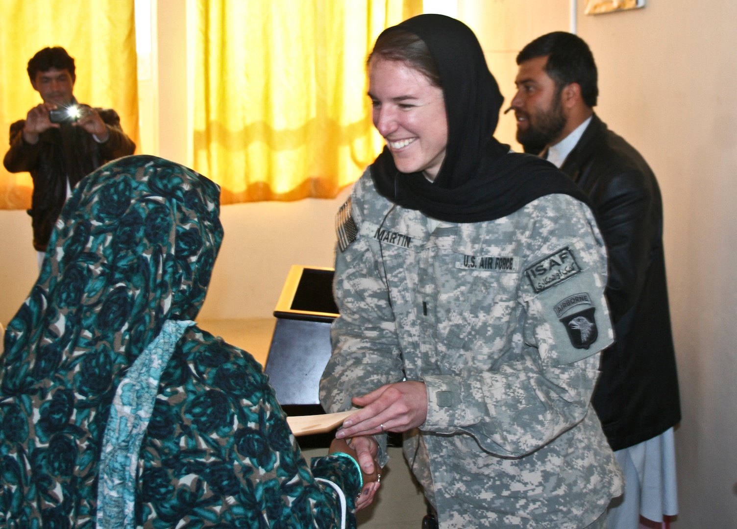 U.S. Air Force 1st Lt. Brittany Martin, right, a public affairs officer with the Laghman Provincial Reconstruction Team, working with 1st Battalion, 133rd Infantry Regiment, Task Force Ironman, which is part of the 2nd Brigade Combat Team, 34th Infantry Division, presents a certificate to an Afghan journalism seminar participant at the Information, Culture and Youth Center in Mehtar Lam, Laghman province, Afghanistan, Feb. 23, 2011. (DoD photo by Staff Sgt. Ryan C. Matson, U.S. Army/Released)