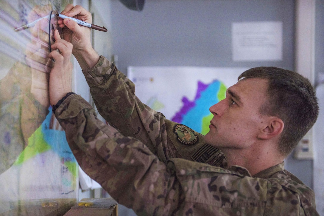 Air Force Staff Sgt. Dakota Karlsen plots coordinates on a map at Bagram Airfield, Afghanistan, Aug. 4, 2016. Karlsen is a controller assigned to the 455th Expeditionary Security Forces Squadron. The command post controllers use maps to identify incident locations in a sector of Bagram. Air Force photo by Senior Airman Justyn M. Freeman