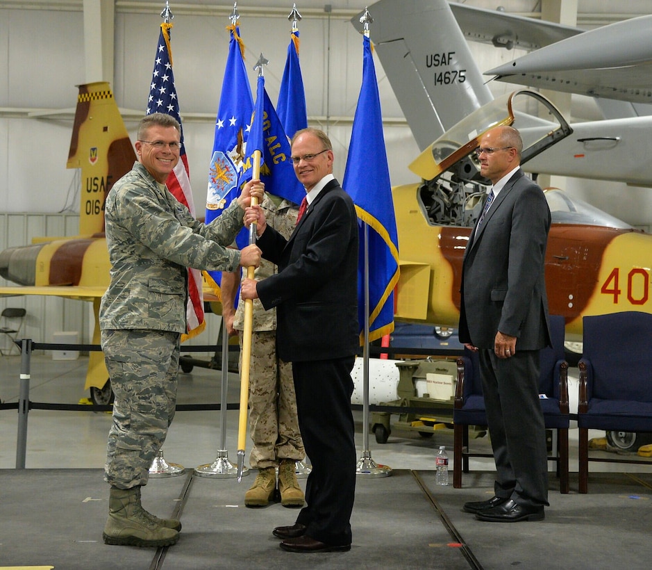 Kelly D. Capener (center) accepts the guidon from Brig. Gen. Steve Bleymaier, Ogden Air Logistics Complex commander, during a 309th Software Maintenance Group change of leadership ceremony July 29, 2016, at Hill Air Force Base, Utah. Capener assumed leadership of the group from Karl G. Rogers (right). (U.S. Air Force photo by R. Nial Bradshaw)