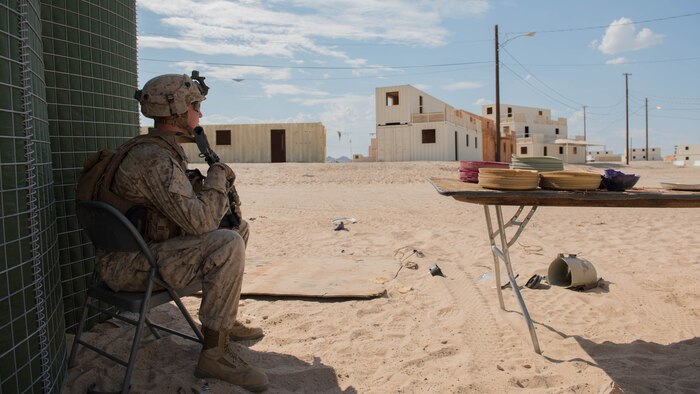 Lance Cpl. Tyler Zaugg, rifleman, Kilo Company, 3rd Battalion, 5th Marine Regiment sits on post outside of a makeshift police station during the Marine Air Ground Task Force Integrated Experiment 2016 at Marine Corps Air Ground Combat Center Twentynine Palms, Calif.  July 29, 2016. The exercise forced Marines to go up against a futuristic oppositional force with access to modern day technology, jamming capabilities, and support from the community.