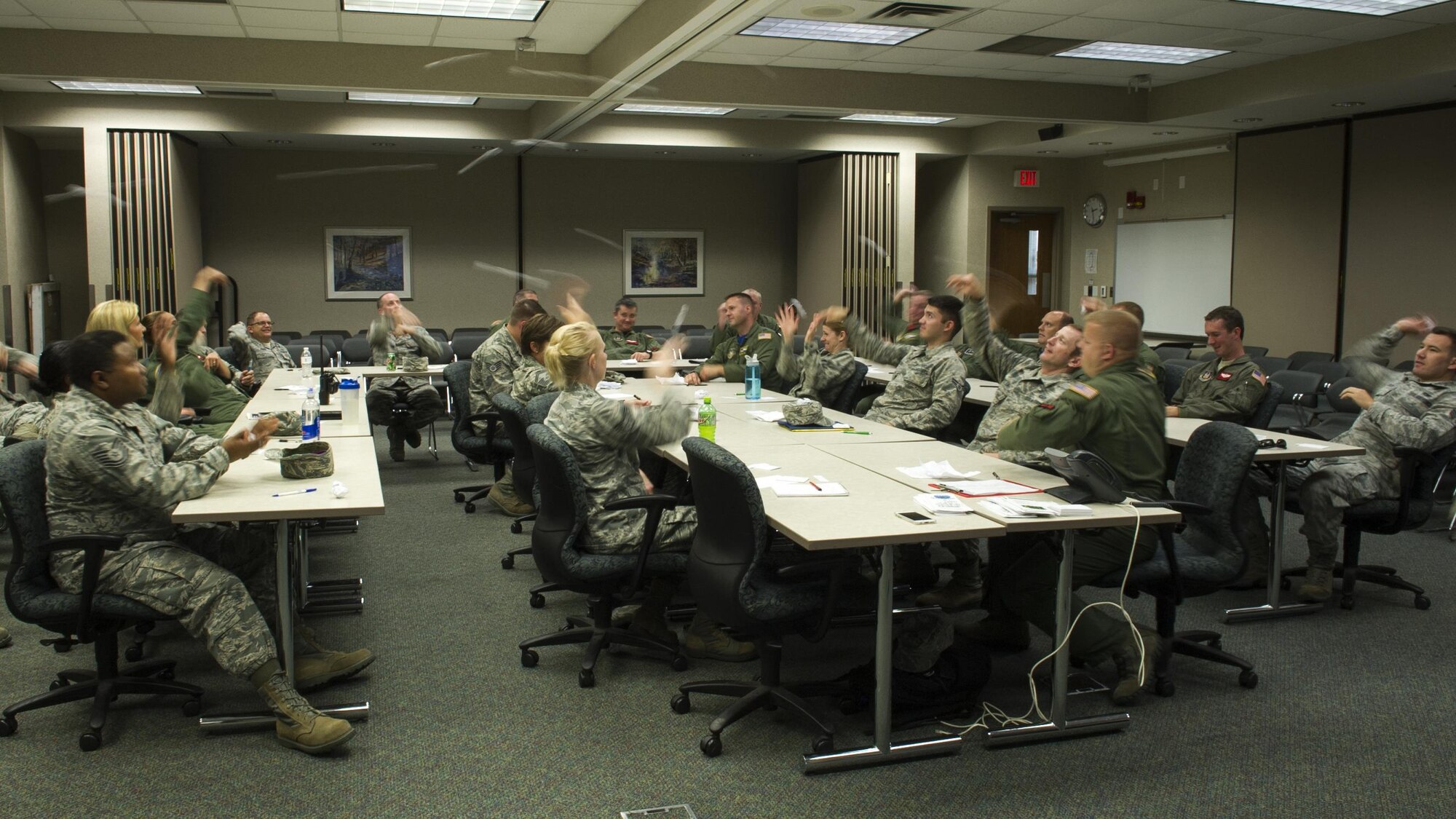 Airmen throw pieces of paper across the room after writing down potential barriers in a realistic scenario involving an act of interpersonal violence during Green Dot training at Grissom Air Reserve Base, Ind., Aug. 6, 2016. Green Dot training differs from traditional bystander intervention by offering scenarios, tools and strategies to deploy in the perpetration of all forms of power-based interpersonal violence and encourages Airmen to directly and indirectly diffuse situations. (U.S. Air Force photo/Staff Sgt. Katrina Heikkinen)  