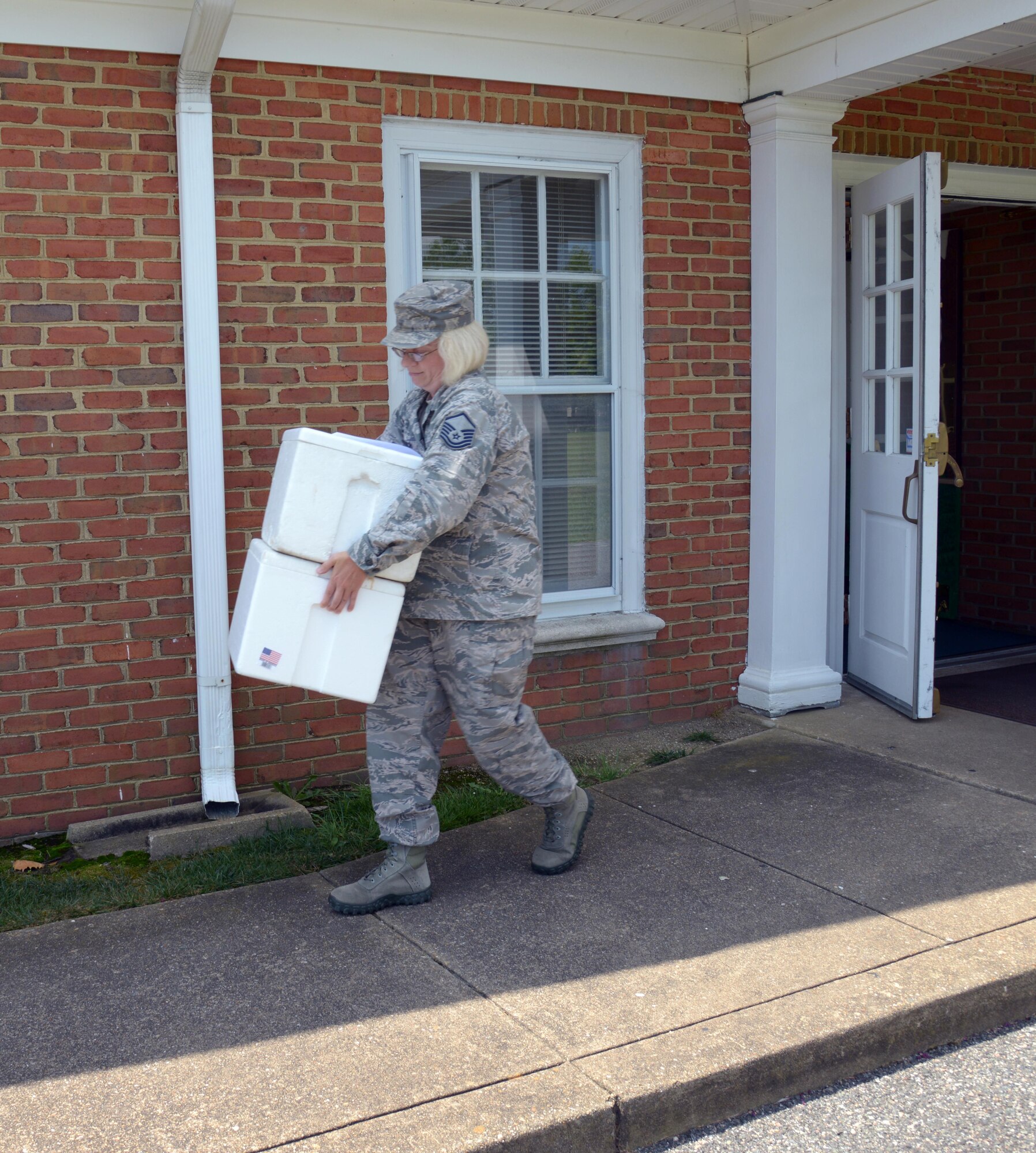 U.S. Air Force Master Sgt. Amy Lynch, Heritage of America Band regional band craftsman takes her assigned meals to her vehicle for her weekly “Meals on Wheels” delivery at Hampton, Va., on July 28, 2016. Joint Base Langley-Eustis volunteers are responsible for delivering meals to 32 of 280 homes in the Hampton Roads community.(U.S. Air Force photo by Tetaun Moffett)