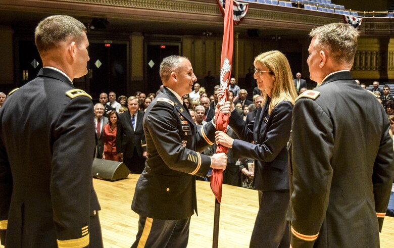 As the new commander, Col. John P. Lloyd passed the flag to Lenna Hawkins, deputy district engineer. This gesture represents the seamless integration of the military and civilian team within the district.