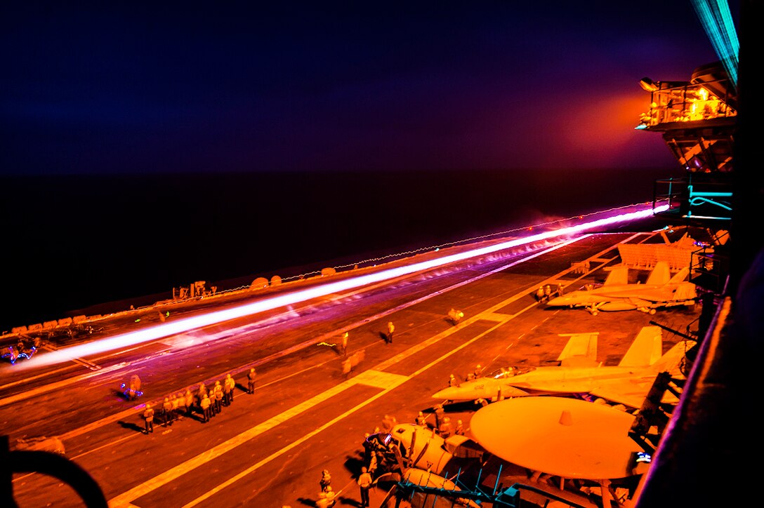 Sailors stand on the flight deck of the aircraft carrier USS Carl Vinson after the successful launch of a Navy F/A-18E Super Hornet assigned to Strike Fighter Squadron 137 during night operations in the Pacific Ocean, Aug. 4, 2016. Navy photo by Seaman Daniel P. Jackson Norgart

