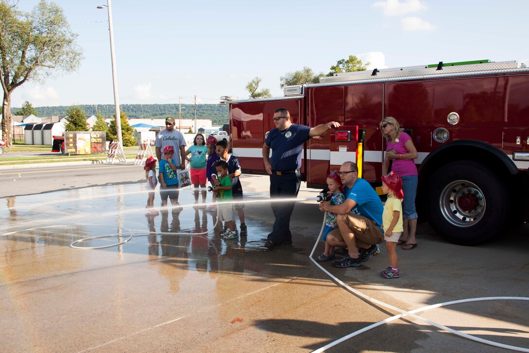 Children challenge each other for accuracy in putting out a fire on a simulated burning building during Defense Distribution Center Susquehanna’s National Night Out on Aug. 2.