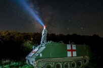 Staff Sgt. Brad Foster, a combat medic with Headquarters and Headquarters Company, 3rd Battalion, 116th Cavalry Brigade Combat Team out of Pendleton, Oregon, watches the night sky on top of an M113 Medical Evacuation Vehicle during Exercise Saber Guardian 16 at the Romanian Land Forces Combat Training Center in Cincu, Romania. 