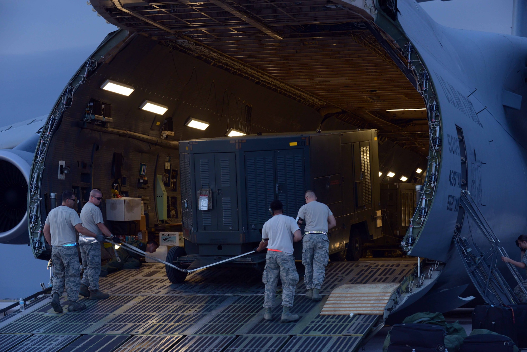 Airmen with the 28th Aircraft Maintenance Squadron guide equipment onto a Dover Air Force Base (AFB), Del., C-5 Galaxy at Ellsworth AFB, S.D., Aug. 2, 2016. The C-5 Galaxy is one of the largest aircraft in the world and has a greater capacity than any other airlifter, with the ability to carry 36 standard pallets and 81 troops simultaneously. (U.S. Air Force photo by Airman Donald Knechtel) 