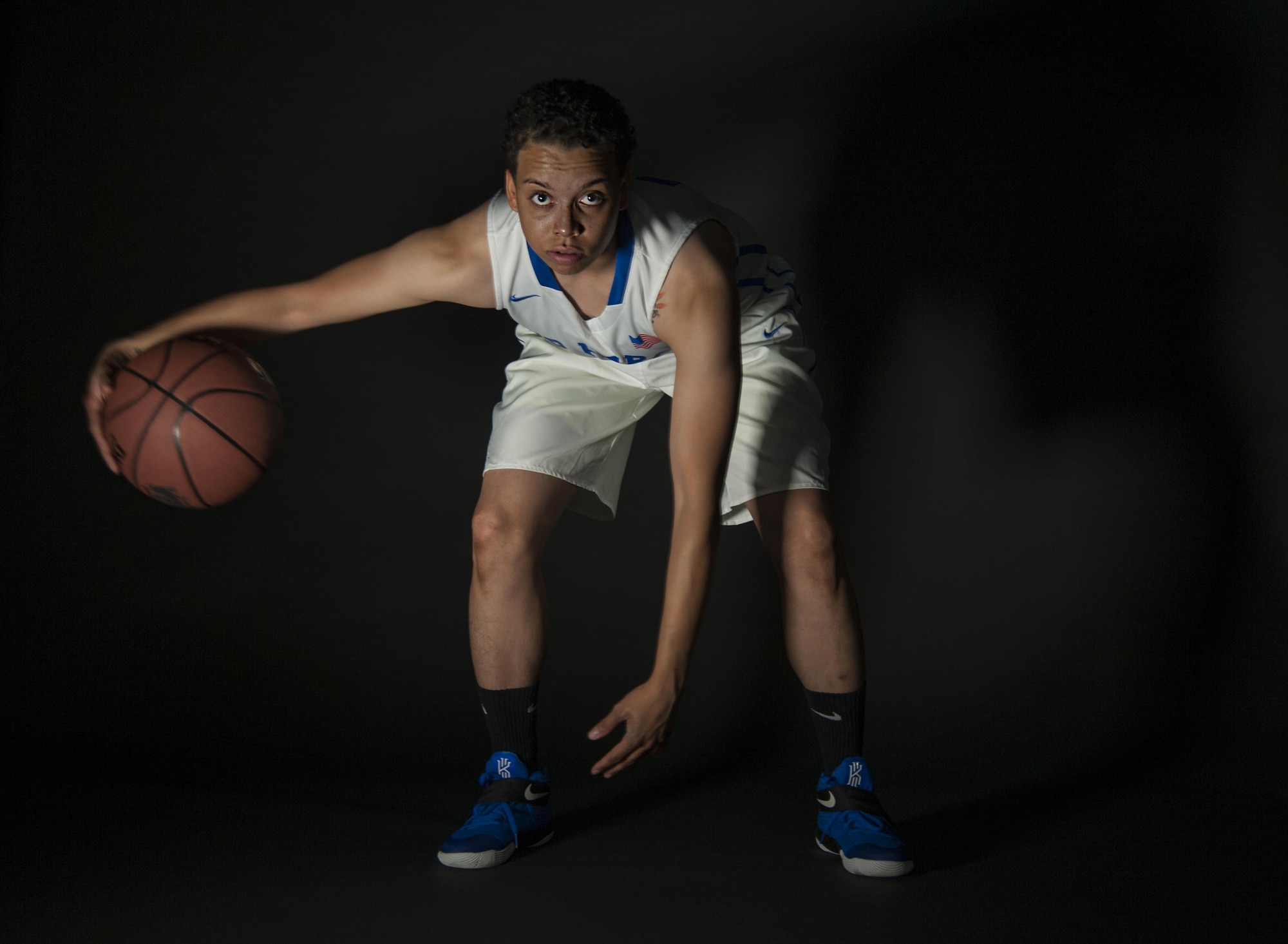 Senior Airman Avery Hale, 5th Maintenance Squadron aerospace ground equipment journeyman, dribbles a basketball in her Air Force basketball uniform at Minot Air Force Base, N.D., Aug. 8, 2016. Hale played point guard for the U.S. Air Force women's team. (U.S. Air Force photo/Airman 1st Class Christian Sullivan)