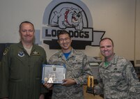 Staff Sgt. Eliaser Martinez, 5th Medical Support Squadron Squadron NCO in charge of storage and distribution, accepts an Own It award from Col. David Ballew, 5th Bomb Wing vice commander, and Chief Master Sgt. Paul Elliott, 5th Bomb Wing command chief, at Minot Air Force Base, N.D., Aug. 5, 2016. After tragedy struck a pharmacy team member, Martinez stepped in to fill a critical role to ensure the mission was completed. (U.S. Air Force photo/Airman 1st Class Christian Sullivan)