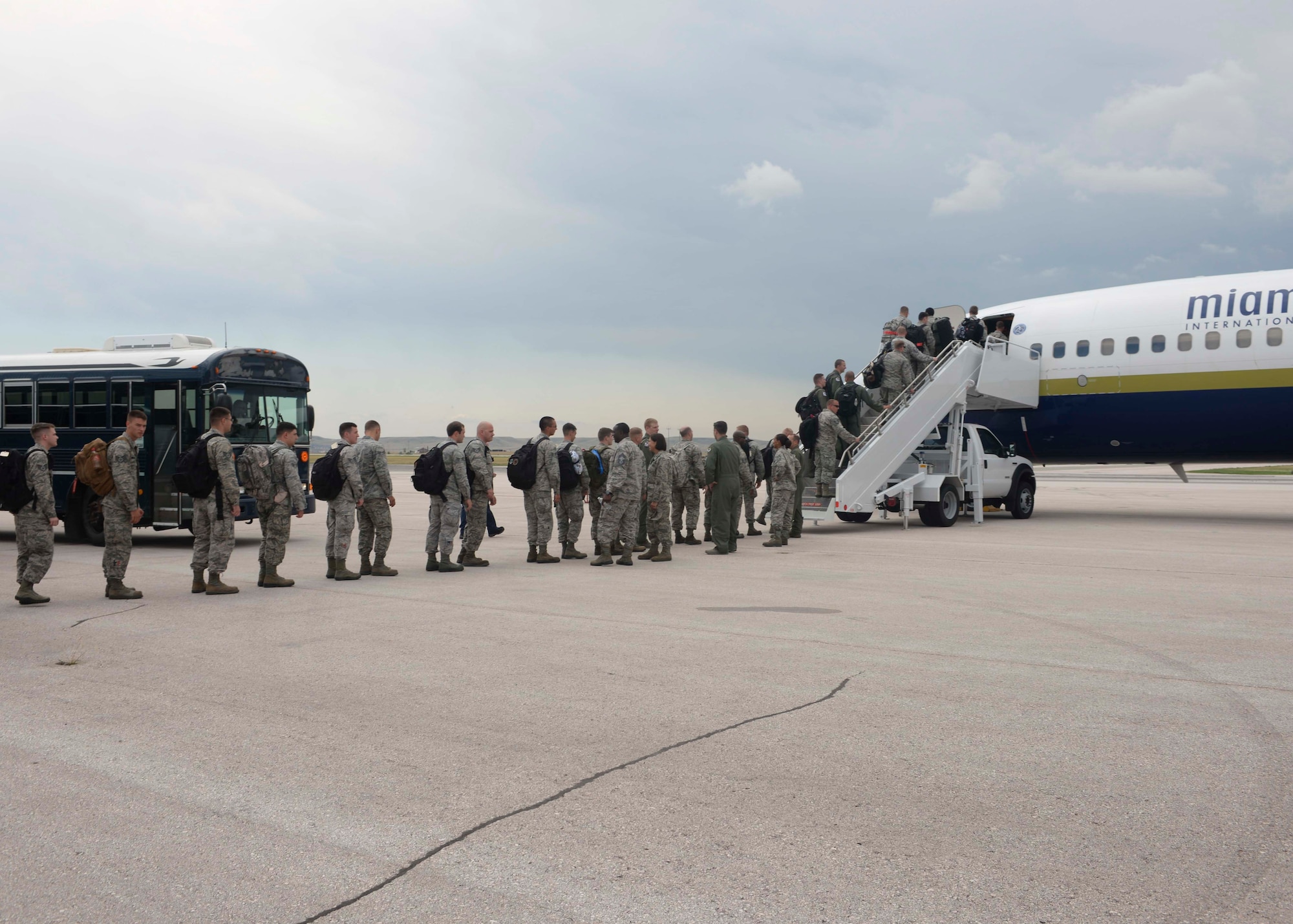 Airmen of the 28th Bomb Wing board a Boeing 737 aircraft at Ellsworth Air Force Base (AFB), S.D., Aug. 1, 2016, as part of a deployment to Andersen AFB, Guam. The Airmen will support B-1 bomber missions as part of the U.S. Pacific Command’s continuous bomber presence mission. (U.S. Air Force photo by Airman 1st Class Sadie Colbert)