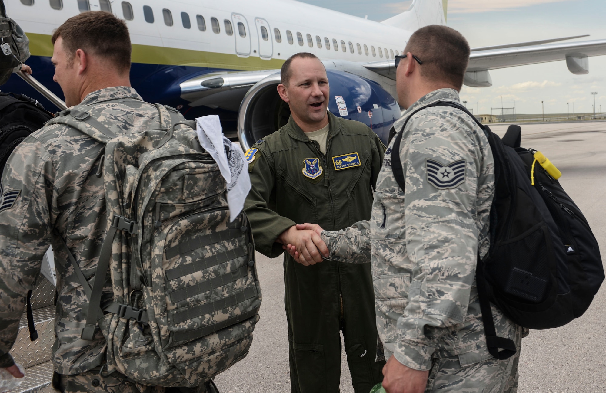 Col. Gentry Boswell, commander of the 28th Bomb Wing, shakes hands with an Airman before they leave for a deployment to Andersen Air Force Base (AFB), Guam, from Ellsworth AFB, S.D., Aug. 1, 2016. While boarding the aircraft, Boswell and other base leaders bid Airmen farewell. (U.S. Air Force photo by Airman 1st Class Sadie Colbert)