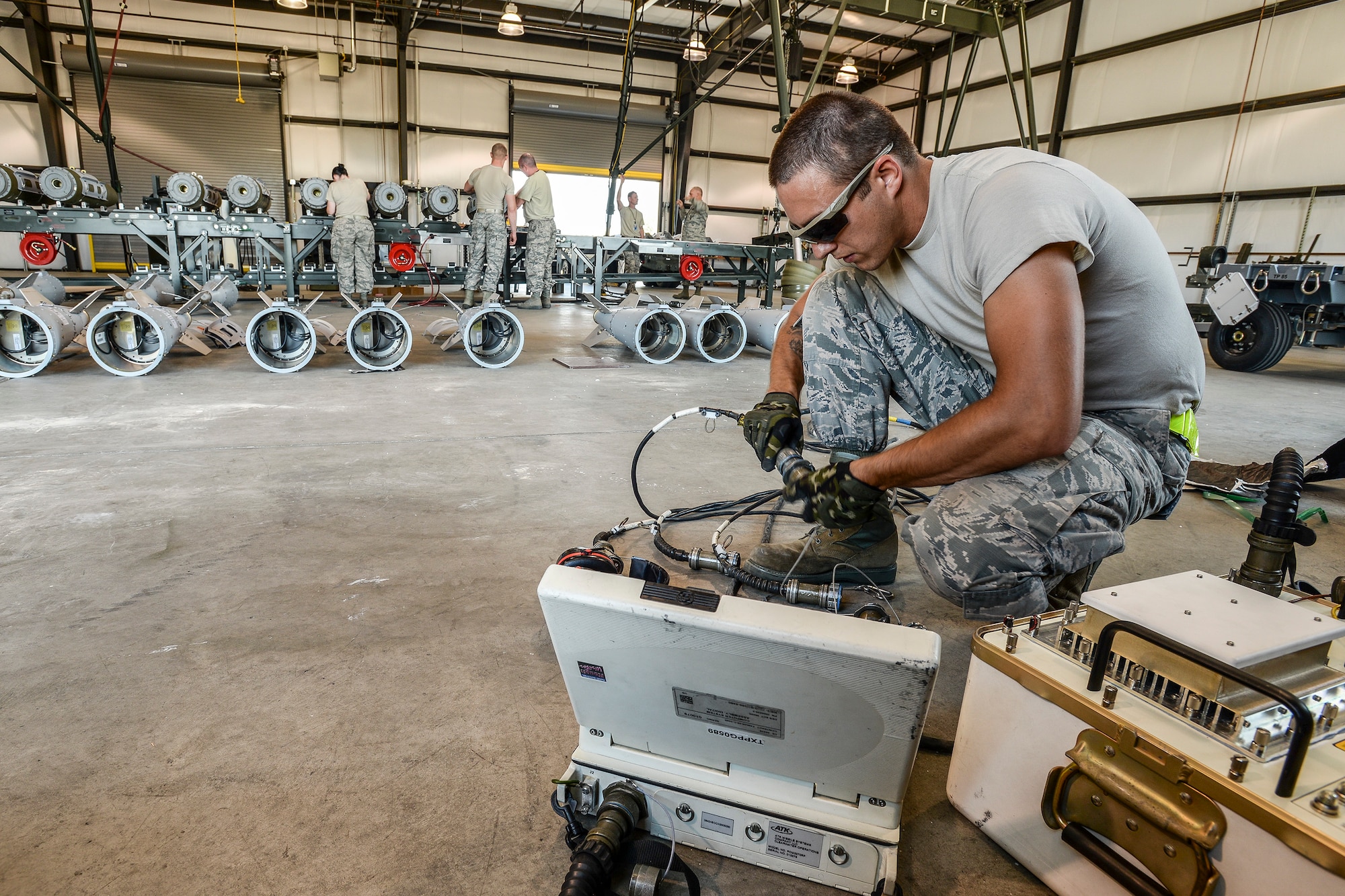 Senior Airman Cameron Kidd, 325th Maintenance Squadron, Tyndall Air Force Base, Fla., readies equipment for loading GPS data into GBU-32 bomb tail sections Aug. 2 at Hill AFB, Utah. The bombs will be dropped at the Utah Test and Training Range during the air-to-ground exercise known as Combat Hammer. Combat Hammer tests precision weapons for performance and suitability for combat. (U.S. Air Force photo by Paul Holcomb)