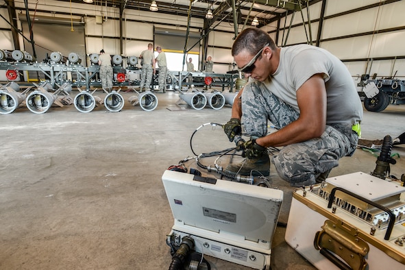 Senior Airman Cameron Kidd, 325th Maintenance Squadron, Tyndall Air Force Base, Fla., readies equipment for loading GPS data into GBU-32 bomb tail sections Aug. 2 at Hill AFB, Utah. The bombs will be dropped at the Utah Test and Training Range during the air-to-ground exercise known as Combat Hammer. Combat Hammer tests precision weapons for performance and suitability for combat. (U.S. Air Force photo by Paul Holcomb)