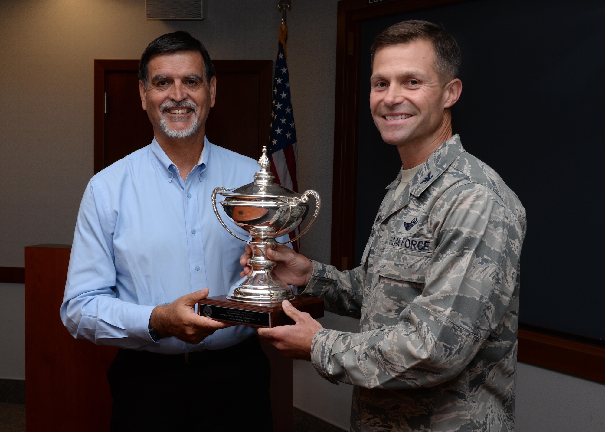 Randy Brown (left), U.S. Air Force Civil Engineer Center director, presents the 2016 Department of Defense Environmental Award for Environmental Restoration, Installation award to Col. Larry Broadwell, 9th Reconnaissance Wing commander, Aug 5, 2016, at Beale Air Force Base, California. Beale received the award for making progress toward cleaning contamination from past defense activities, maintaining partnerships to improve species habitat and minimizing groundwater contamination. (U.S. Air Force photo by Robert Scott)