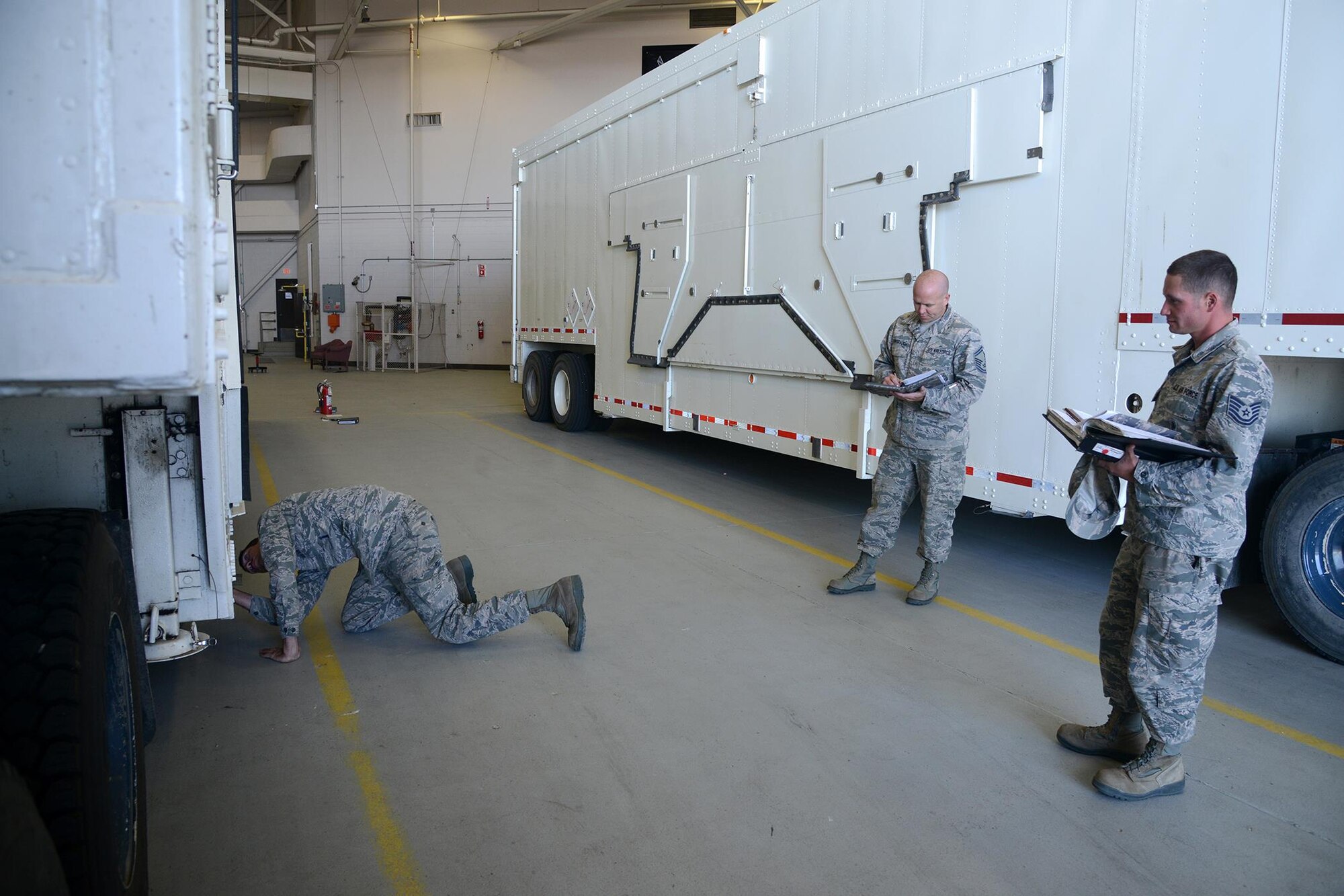 Senior Master Sgt. Brian Newbraugh, center, 341st Maintenance Group superintendent of quality assurance, performs an evaluator proficiency evaluation on Tech. Sgt. Michael Adams, right, 741st Maintenance Squadron missile maintenance technician evaluator while he assesses Senior Airman Austin Bridges performing an operational checkout Aug. 5, 2016, at Malmstrom Air Force Base, Mont. The evaluators refer to the technical orders while the Airmen being evaluated check for damage and verify that the appropriate placards and environmental flags are displayed. (U.S. Air Force photo/Staff Sgt. Delia Marchick)