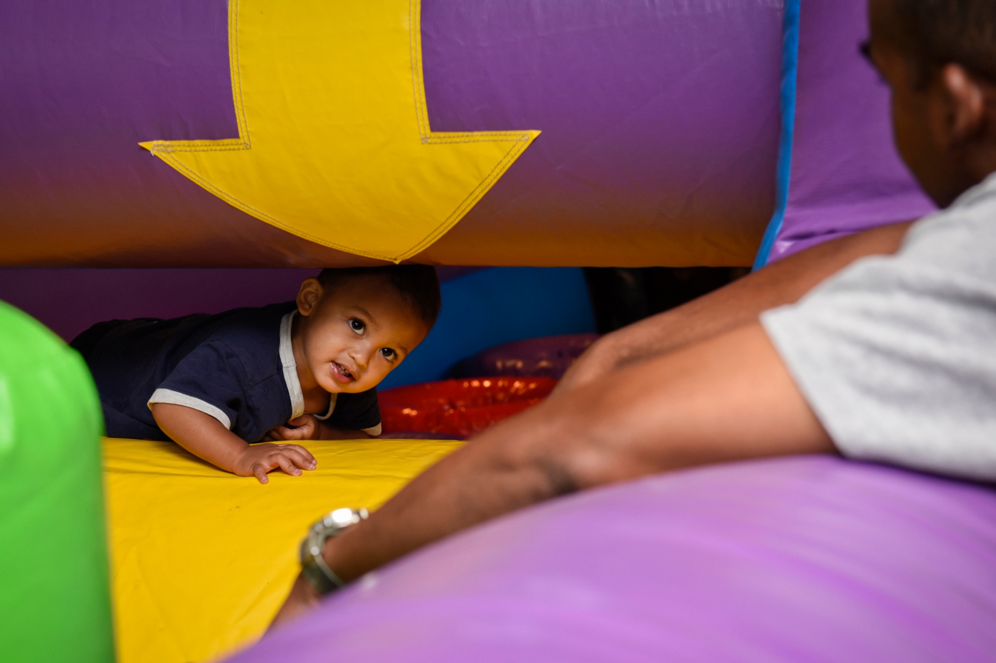 Christian Nicholson looks to his father as he climbs through an inflatable course at the Family Festival and Concert at The Club on Peterson Air Force Base, Colo., Aug. 6, 2016. The annual event was put on by the 21st Force Support Squadron and was held in conjunction with the Deployed Family Member Dinner. (U.S. Air Force photo by Senior Airman Rose Gudex)