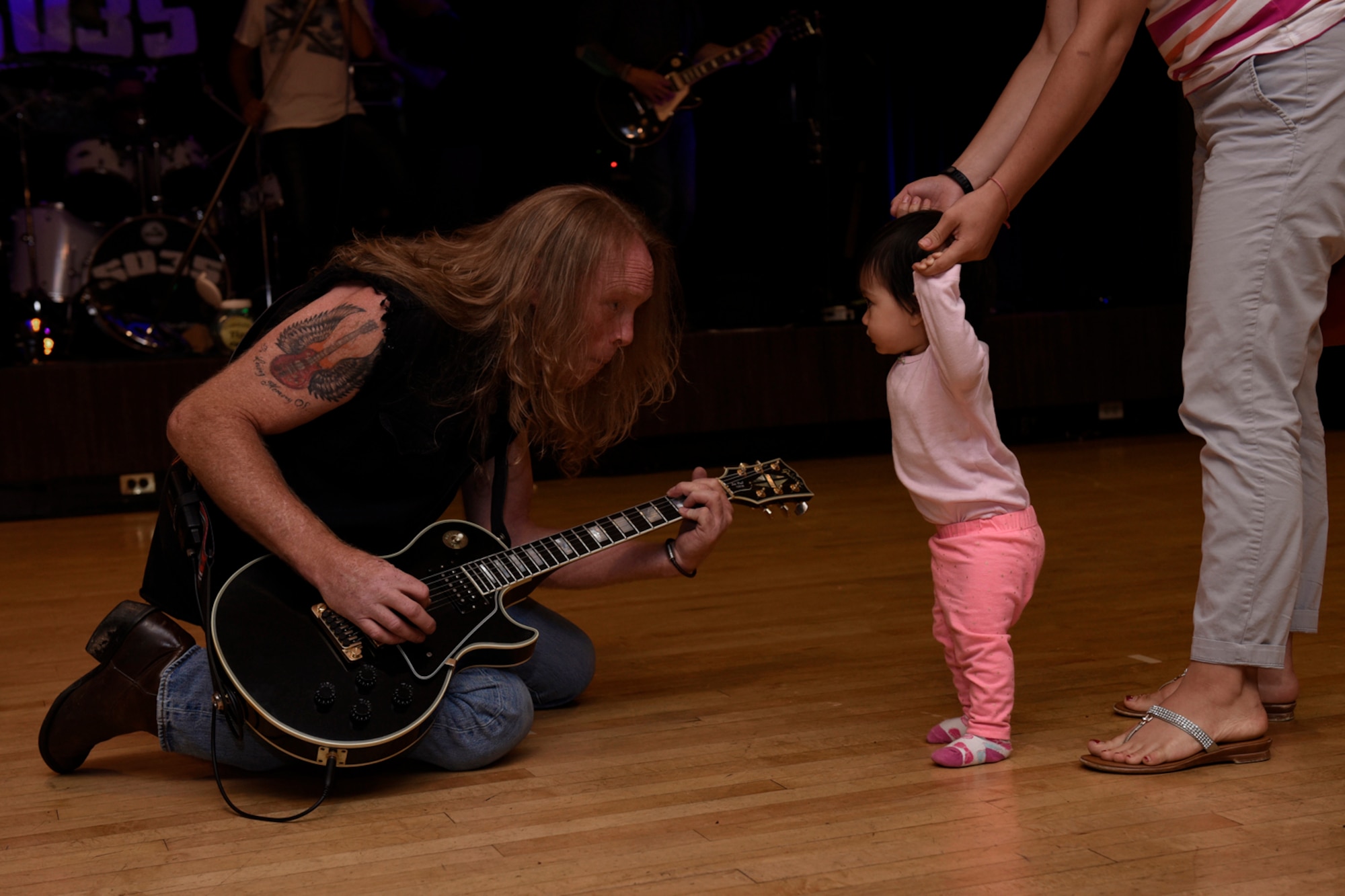 A member of the rock band 6035 sings for Milana Paulina Rodriguez at the Family Festival and Concert at The Club on Peterson Air Force Base, Colo., Aug. 6, 2016. The event was free and open to anyone with base access. (U.S. Air Force photo by Senior Airman Rose Gudex)