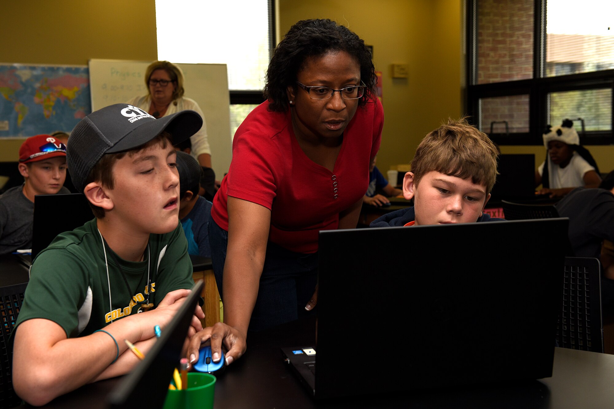 Carol Rieping, STARBASE Academy teaching assistant, helps students with an engineering project during the STEM Camp at Peterson Air Force Base, Colo., Aug. 4, 2016. A field trip to Challenger Learning Center for the Voyage to Mars simulation was also part of the camp. (U.S. Air Force photo by Senior Airman Rose Gudex)