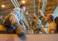 U.S. Air Force Staff Sgt. Corey Holt and Senior Airman Shane Sells, both assigned to the 8th Maintenance Squadron, Kunsan Air Base (AB), Republic of Korea, and Staff Sgt. Corey Holt, assigned to the 35th Maintenance Squadron, Misawa AB, Japan, all aircrew egress systems technicians, celebrate after bolting an injection seat that was difficult to reach into an F-16D Fighting Falcon aircraft Aug. 9, 2016, during RED FLAG-Alaska (RF-A) 16-3 at Eielson Air Force Base, Alaska. The maintenance Airmen combined skills, saving 50 percent on man-hours and temporary duty funds, increasing coverage from 12 to 24 hours during RF-A 16-3. (U.S. Air Force photo by Staff Sgt. Shawn Nickel)