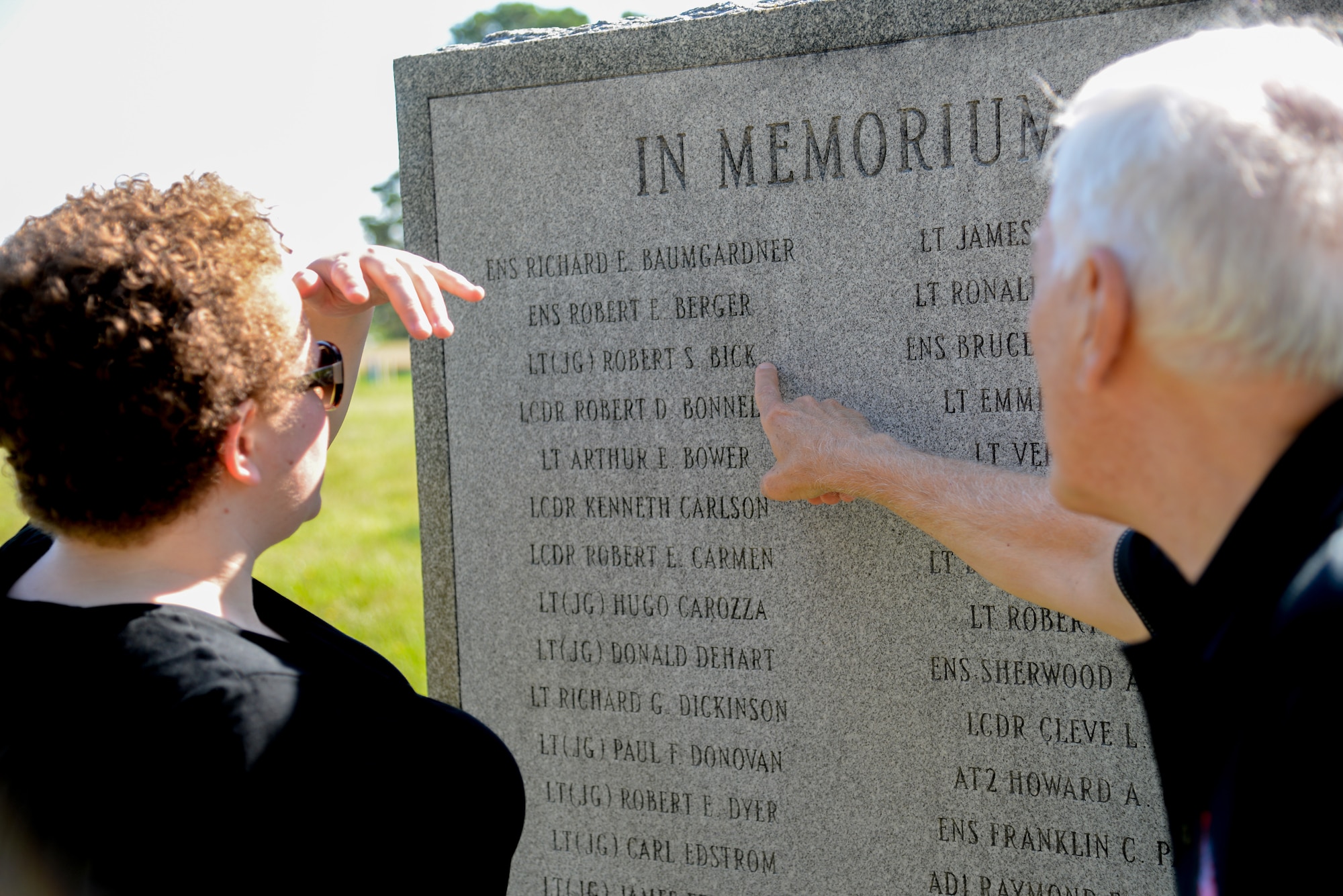 A picture of Dr. Richard Porcelli, local aviation historian, pointing out a name inscribed on a U.S. Navy VC-4 memorial marker to Melissa Swanson, Naval History and Heritage Command Conservator.