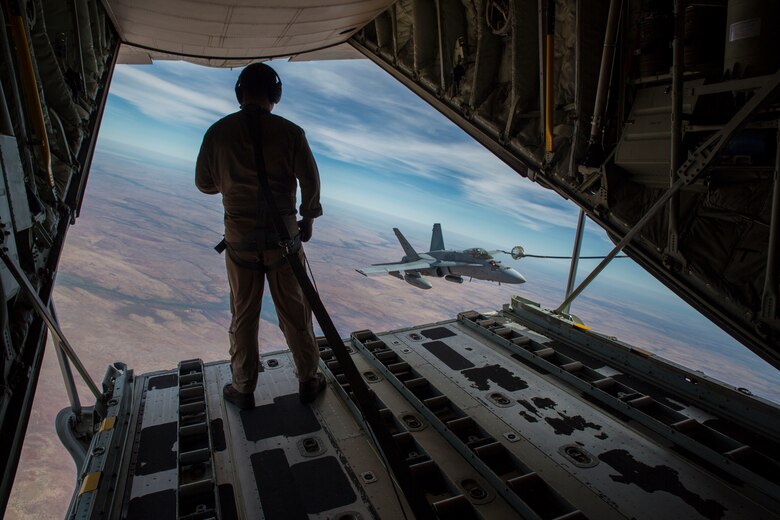 U.S. Marine Corps Cpl. Chris Lawler, a crewmaster with Marine Aerial Refueler Transport Squadron (VMGR) 152, observes an F/A-18C Hornet with Marine Fighter Attack Squadron (VMFA) 122 approach the refueling hose during Exercise Pitch Black 2016 at Royal Australian Air Force Base Tindal, Australia, Aug. 9, 2016. VMGR-152 provides aerial refueling and assault support during expeditionary, joint and combined operations like Pitch Black. This exercise is a biennial, three week, multinational, large-force training exercise hosted by RAAF Tindal. (U.S. Marine Corps photo by Cpl. Nicole Zurbrugg)