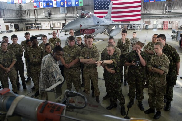 U.S. Air Force Master Sgt. Mandingo Alfred, 52nd Maintenance Squadron weapons superintendent, center left, answers questions from Royal Air Force Air Cadets during a tour at Hangar One on Spangdahlem Air Base, Germany, Aug. 9, 2016. Air Cadets, a United Kingdom-wide cadet force with more than 40,000 members aged between 12 and 20 years old, received an in-depth tour of 52nd Fighter Wing assets including the base fire department and an F-16 Fighting Falcon fighter aircraft. (U.S. Air Force photo by Airman 1st Class Preston Cherry/Released)