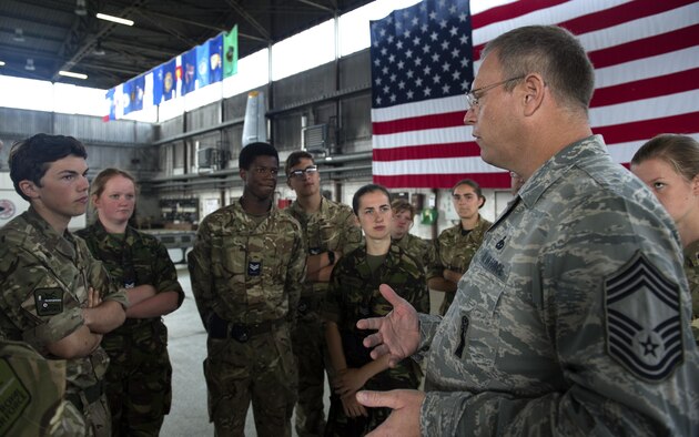 U.S. Air Force Chief Master Sgt. Craig Brandenburg, 52nd Maintenance Group wing weapons manager, right, speaks to Royal Air Force Air Cadets during a tour at Hangar One on Spangdahlem Air Base, Germany, Aug. 9, 2016. Air Cadets, a United Kingdom-wide cadet force with more than 40,000 members aged between 12 and 20 years old, received an in-depth tour of 52nd Fighter Wing assets including the base fire department and an F-16 Fighting Falcon fighter aircraft. (U.S. Air Force photo by Airman 1st Class Preston Cherry/Released)