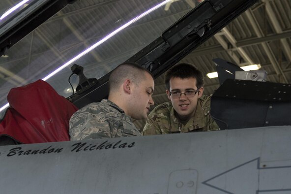 U.S. Air Force 2nd Lt. Brandon Kirby, 52nd Maintenance Group quality assurance officer-in-charge, left, shows a Royal Air Force Air Cadet the cockpit of an F-16 Fighting Falcon fighter aircraft assigned to the 480th Fighter Squadron during a tour at Hangar One on Spangdahlem Air Base, Germany, Aug. 9, 2016. Air Cadets, a United Kingdom-wide cadet force with more than 40,000 members aged between 12 and 20 years old, received an in-depth tour of 52nd Fighter Wing assets including the base fire department and an F-16. (U.S. Air Force photo by Airman 1st Class Preston Cherry/Released)