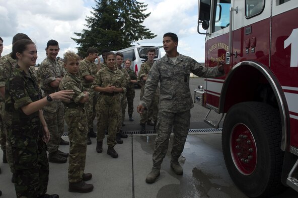 U.S. Air Force Staff Sgt. Joshua Vasquez, a 52nd Civil Engineer Squadron fire department crew chief, center, gives Royal Air Force Air Cadets a look at a fire engine during a tour on the flightline at Spangdahlem Air Base, Germany, Aug. 9, 2016. Air Cadets received a guided tour of base assets from members of the 52nd Fighter Wing Community Relations, 52nd Maintenance Group and 52nd CES to include the F-16 Fighting Falcon fighter aircraft and fire department. (U.S. Air Force photo by Airman 1st Class Preston Cherry/Released)