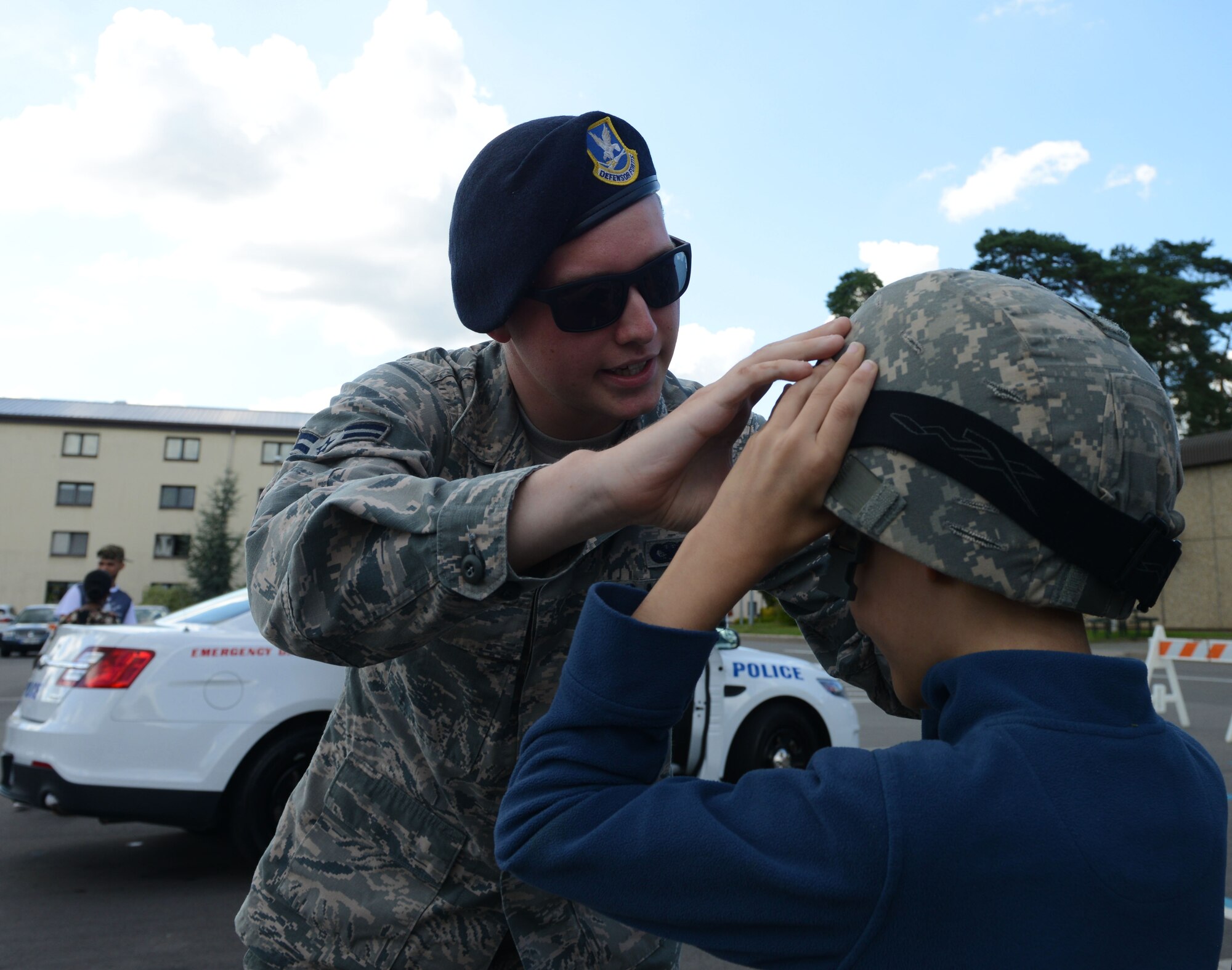 Airman 1st Class Joseph Marsden, 86th Security Forces Squadron security forces member, helps a child put on a helmet during a block party Aug. 5, 2016, at Ramstein Air Base, Germany. The Ramstein Enlisted Club hosted the block party which included static displays from the 86th SFS and the 86th Civil Engineer Squadron firefighters. (U.S. Air Force photo/ Airman 1st Joshua Magbanua)
