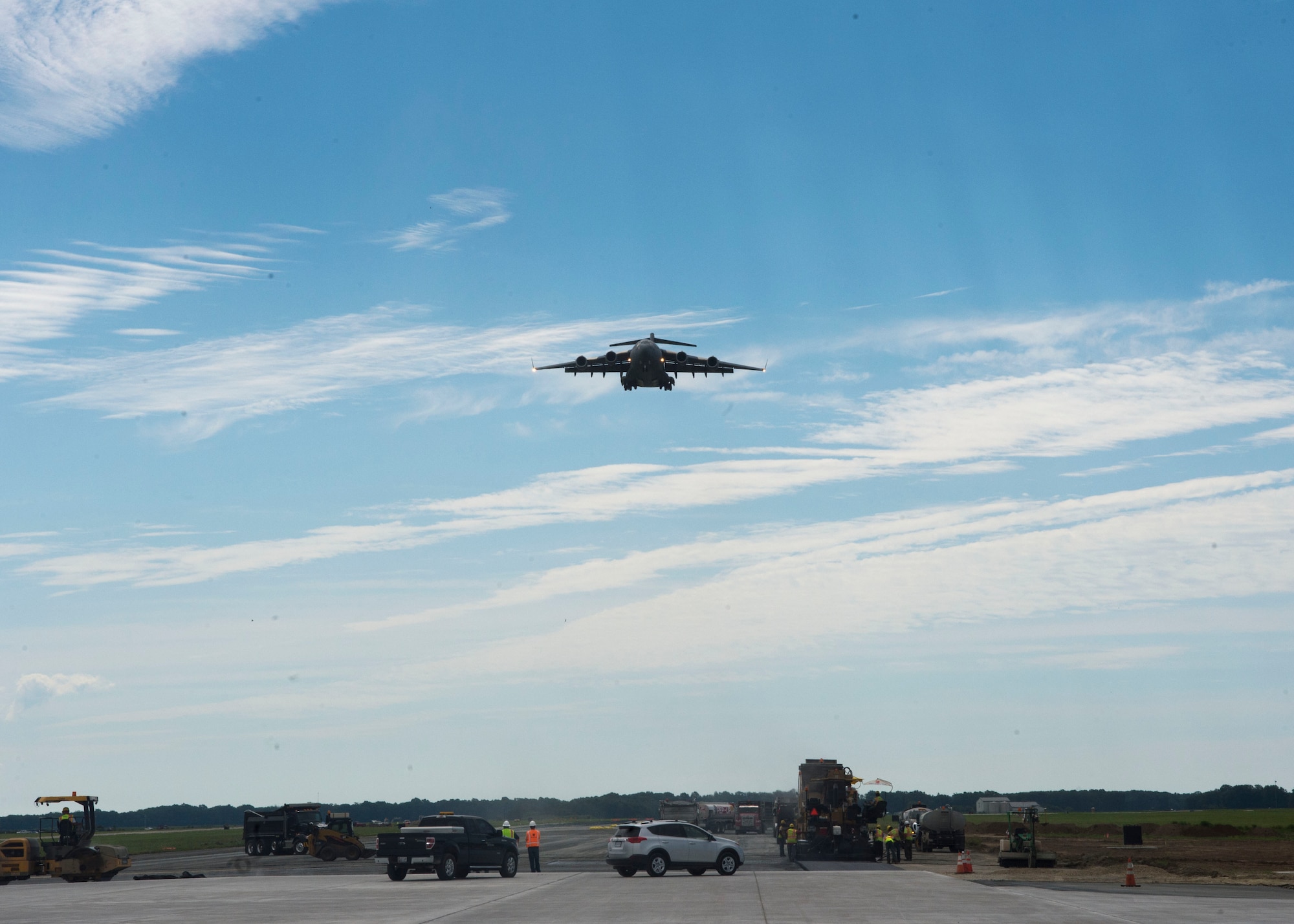 Construction workers watch a C-17 Globemaster III come in for landing Aug. 8, 2016, Dover Air Force Base, Del. Dover’s main runway is currently under construction.