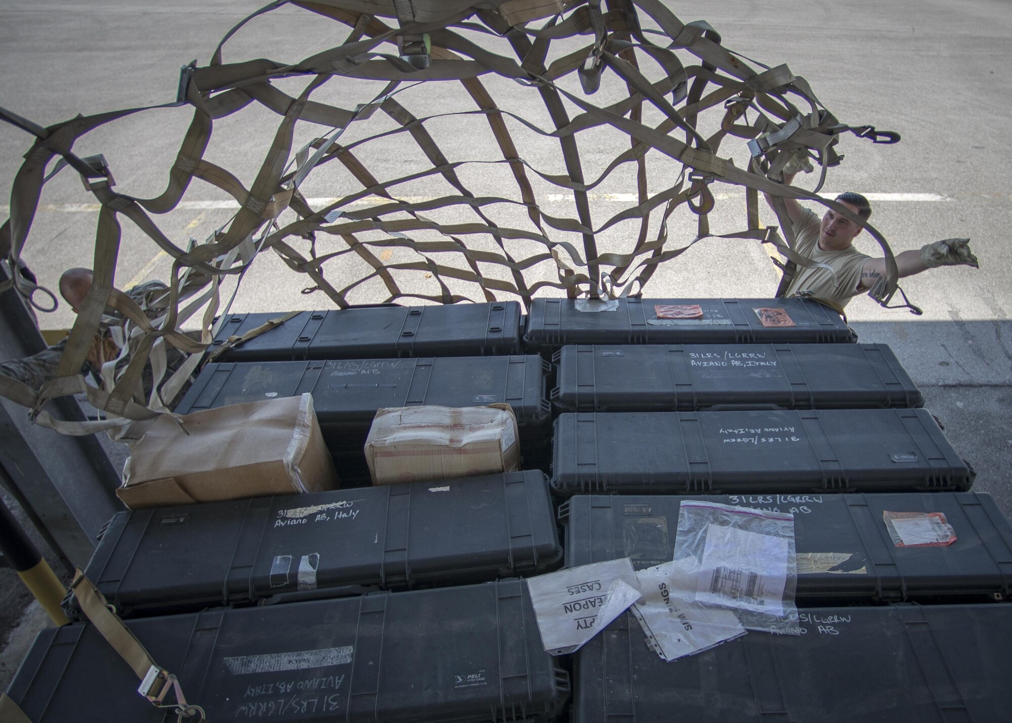 Staff Sgt. Patrick Staunton and Senior Airmen Cameron Jones, 31st Maintenance Squadron phase inspection team members, participate in a cargo preparation and pallet build-up training Aug. 8, 2016, at Aviano Air Base, Italy. Nets and straps are used to secure the aircraft’s cargo onto pallets. The straps are tested to withstand up to 8 G-Forces during transportation. (U.S. Air Force photo by Airman 1st Class Cory W. Bush/Released)