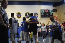 Teammates hug Jonathan Holden, 50th Space Wing, after he sunk the game-winning shot against the 21st Space Wing during Tri-Wing Sports Day at Schriever Air Force Base, Colorado, Friday, Aug. 5, 2016. The win gave the basketball team a 2-0 record, and earned the wing valuable points as it looked to win the Tri-Wing trophy. (U.S. Air Force photo/Staff Sgt. Matthew Coleman-Foster)