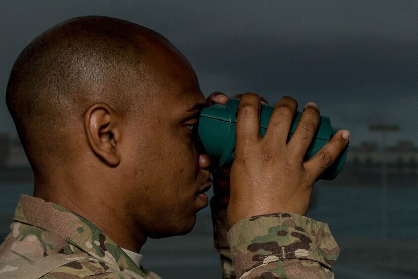 U.S. Army Spc. Antony Delgado, 203rd Transportation Detachment water craft operator, keeps watch during pre-deployment training at Fort Eustis, Va., Aug. 2, 2016. The virtual reality binoculars allow a realistic view for Soldiers who are assigned as lookouts during the training exercise. (U.S. Air Force photo by Airman 1st Class Derek Seifert)