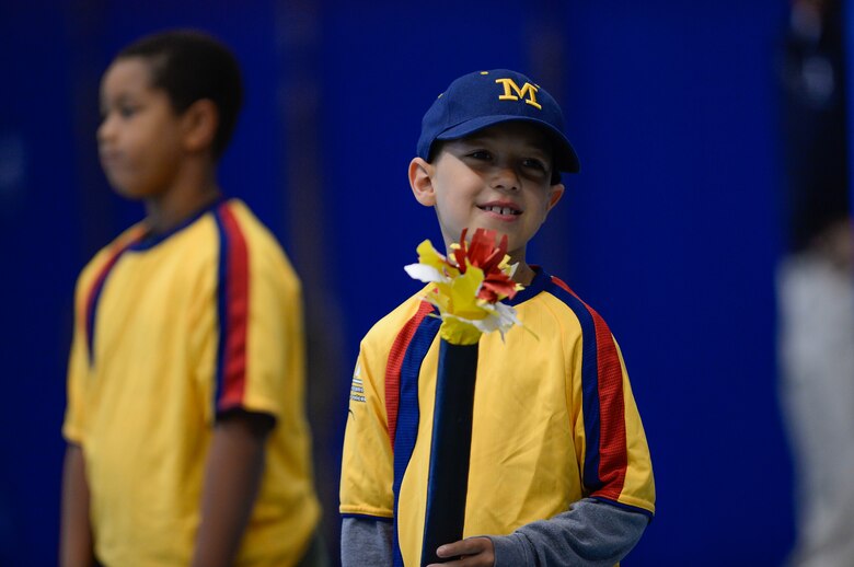 Gabriel Allen, Schriever School Age Care program student, holds a torch during the opening ceremony of the Tri-Wing Sports Day at Schriever Air Force Base, Colorado, Friday, Aug. 5, 2016. Allen was one of several SAC students who served as torch bearers for the event. (U.S. Air Force photo/Christopher DeWitt)