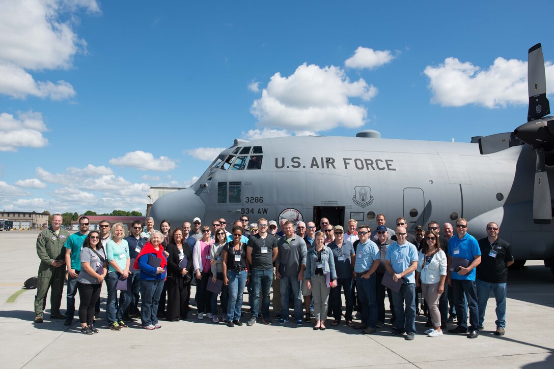 Civilian Employers of Reservists pose next to the C-130 Hecules they flew on during Employers Day Aug. 6.