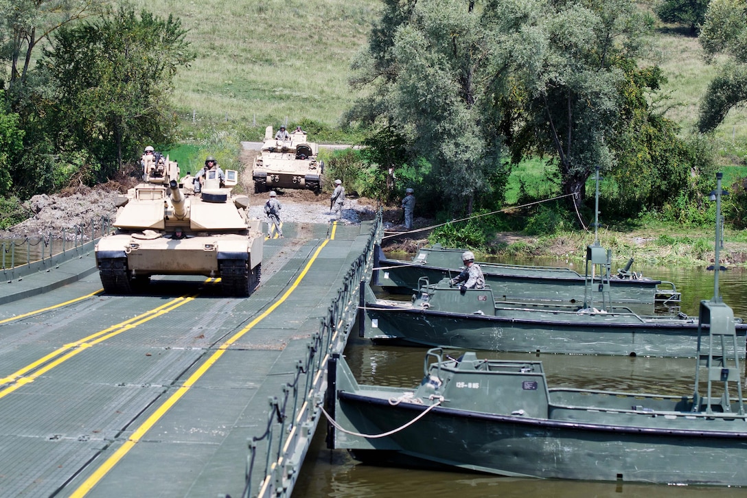 Soldiers drive their M1A2 Abrams tank across an improved ribbon bridge on the Olt River near Voila, Romania, during Exercise Saber Guardian 16, Aug. 1, 2016. The soldiers are assigned to the Idaho National Guard’s 116th Cavalry Brigade Combat Team. Army photo by 1st Sgt. Kevin Hartman