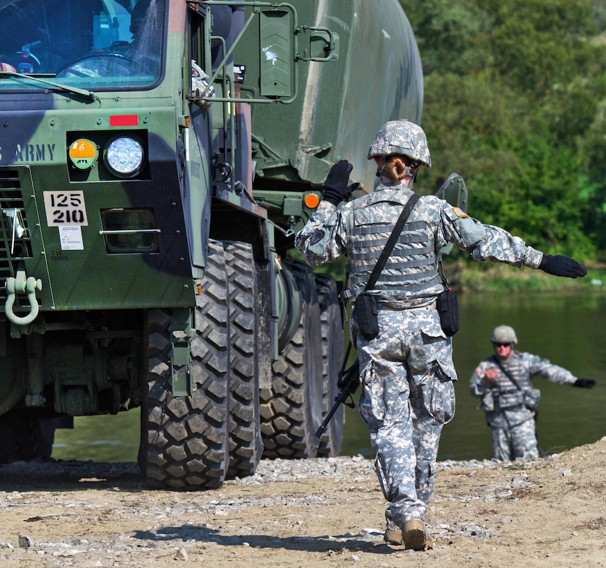 Soldiers give directions to a driver preparing to release a portion of an improved ribbon bridge into the Olt River near Voila, Romania, during Exercise Saber Guardian 16, Aug. 1, 2016. Army photo by 1st Sgt. Kevin Hartman