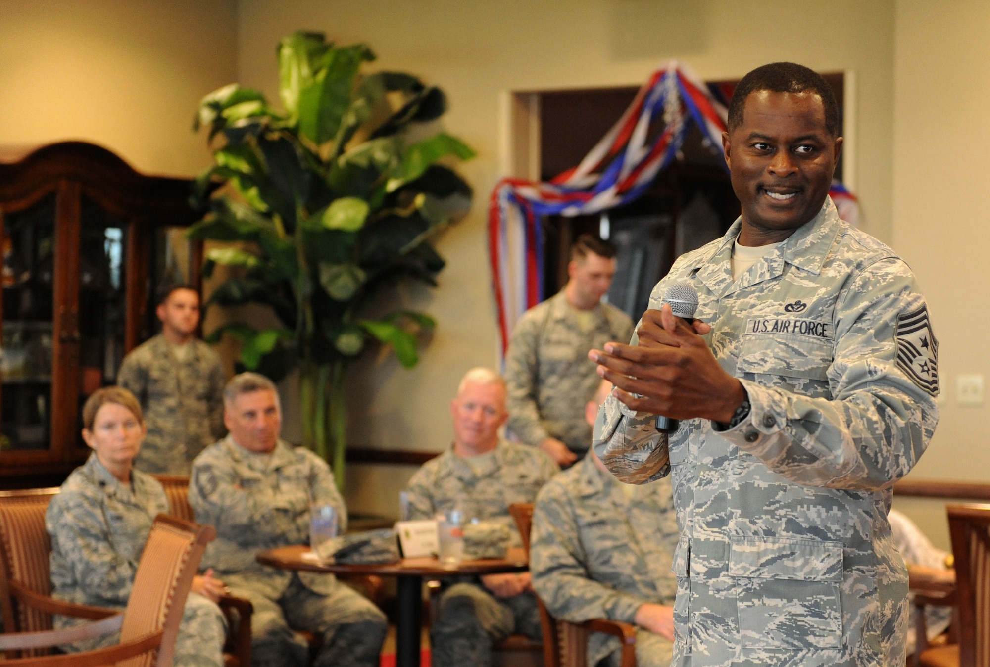 Chief Master Sgt. Harry Hutchinson, 81st Training Wing command chief, delivers remarks about Tech. Sgt. Cassandra Cruz, 81st Force Support Squadron Airman Leadership School instructor, during a recognition ceremony for her selection as one of the 12 Outstanding Airmen of the Year at the Bay Breeze Event Center Aug. 2, 2016, on Keesler Air Force Base, Miss. This award recognizes 12 enlisted personnel for their superior leadership, job performance, community involvement and personal achievements. (U.S. Air Force photo by Kemberly Groue/Released)