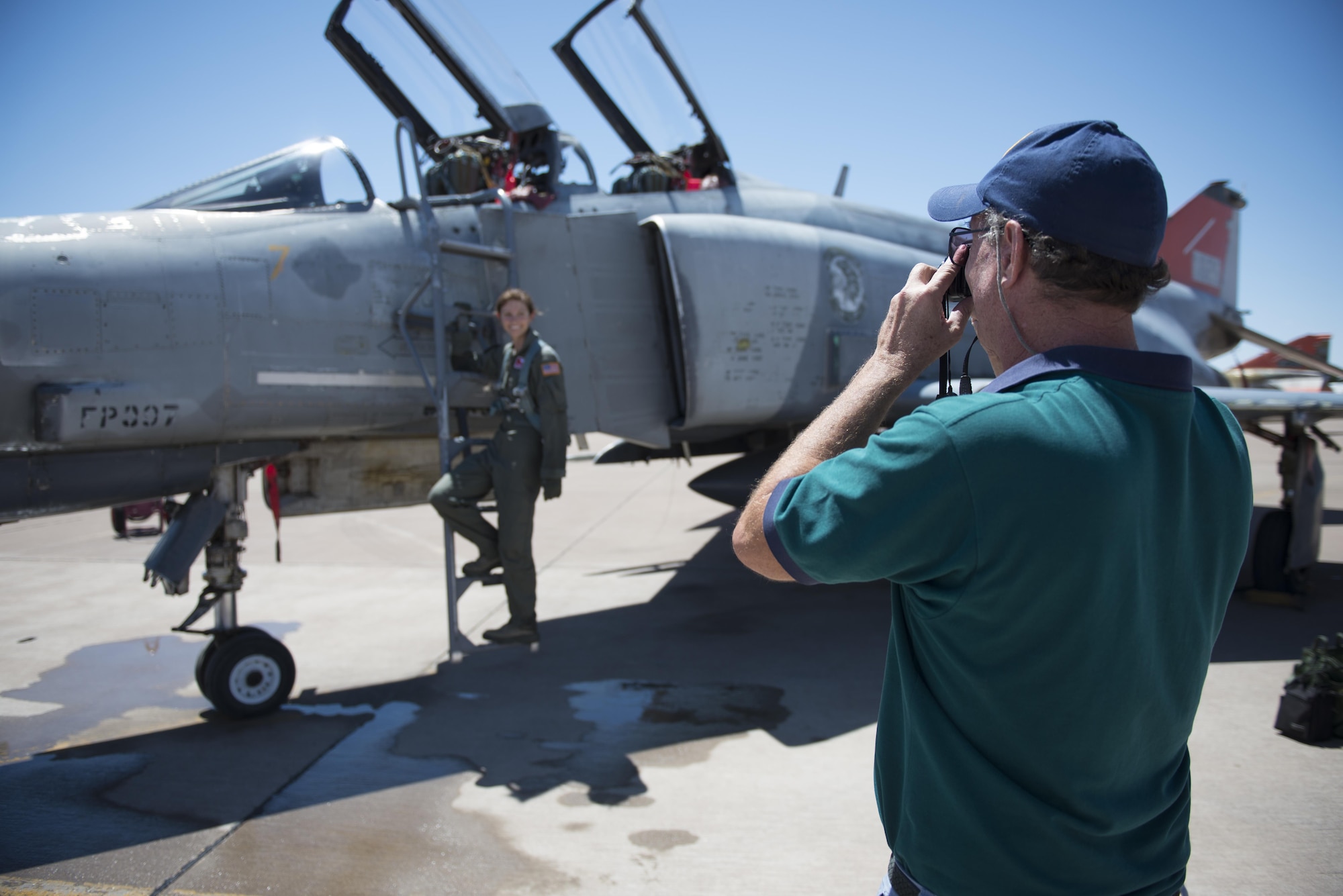 Retired Col. David takes a photo of his daughter, Cadet 2nd Class Kaitlyn, standing next to an F-4 Phantom on July 12, 2016 at Holloman Air Force Base, N.M. David came to surprise his daughter, a junior at the Air Force Academy, after her first flight in a fighter jet with the 96th Test Group Detachment 1. (Last names are being withheld due to operational requirements. U.S. Air Force photo by Airman 1st Class Randahl J. Jenson) 
