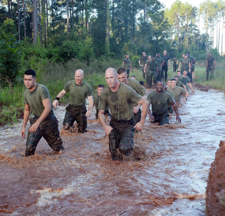With red Georgia clay caked on their boots and camouflage utility uniform, Marines with Headquarters Company East, Marine Corps Logistics Command, trudge through several mud pits during a motivation run held aboard Marine Corps Logistics Base Albany, July 28.