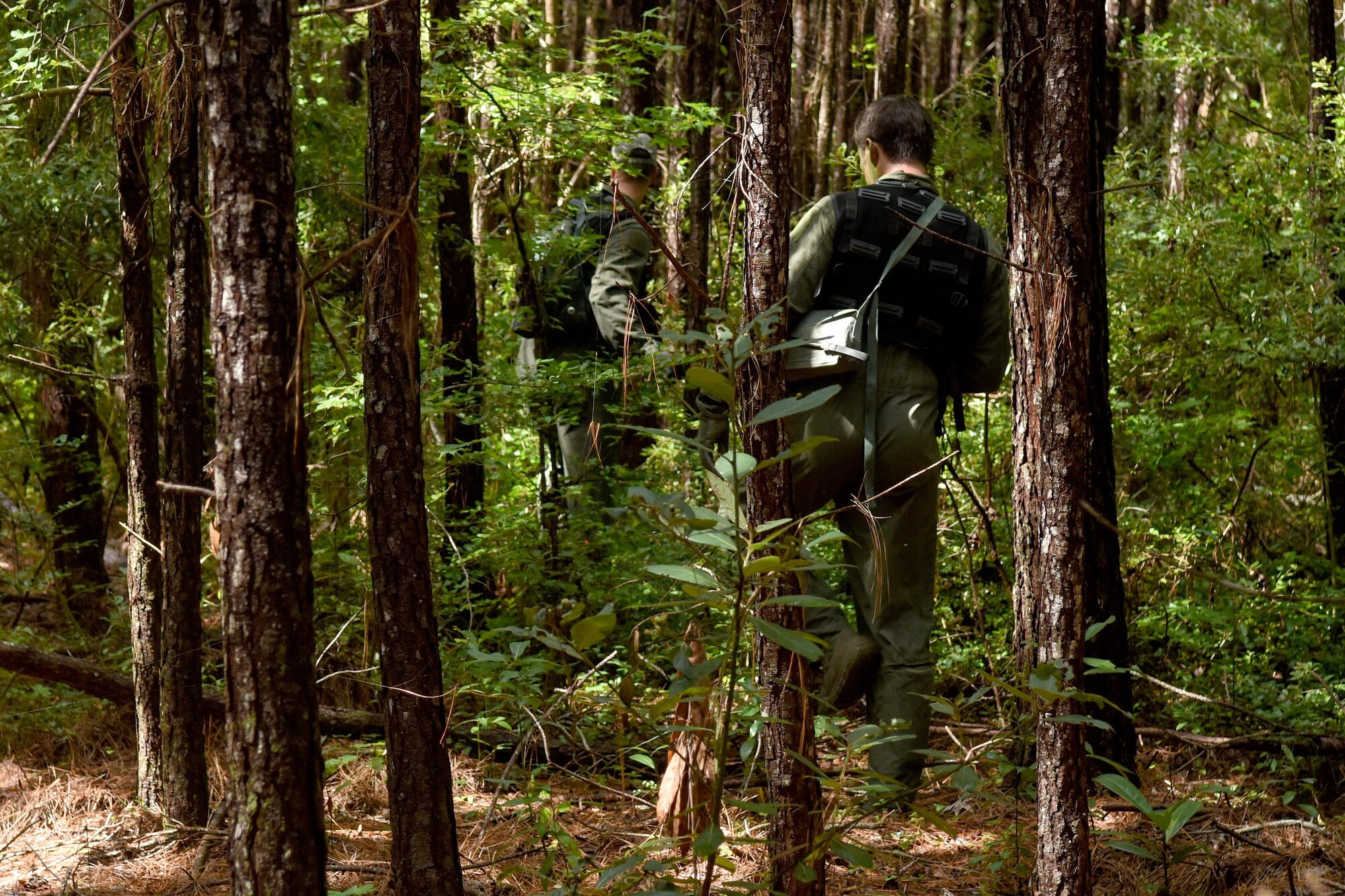 First Lieutenants James Hendershaw (left), 336th Fighter Squadron weapon systems officer, and Michael McCoy, 336th FS pilot, evade simulated threats during the Razor Talon exercise Aug. 5, 2016, near Smyrna, North Carolina. The aircrew members used their survival, evasion, resistance and escape training, while attempting to contact their wingmen for aerial support following a simulated aircraft crash in a hostile environment. (U.S. Air Force photo by Airman Shawna L. Keyes)